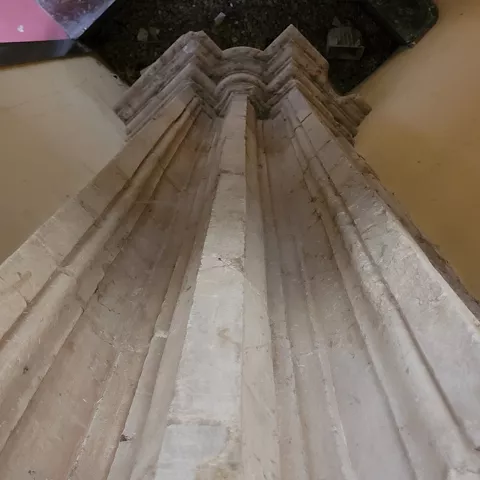 Pilar gótico de piedra en interior histórico.