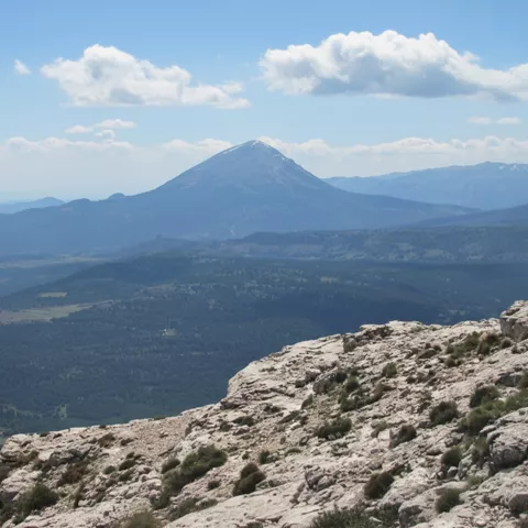 Vista panorámica de montaña solitaria desde terreno rocoso.