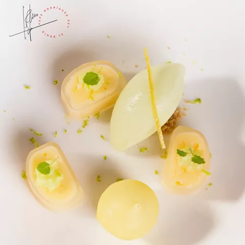 Postre emplatado con formas geométricas y decoración cítrica.