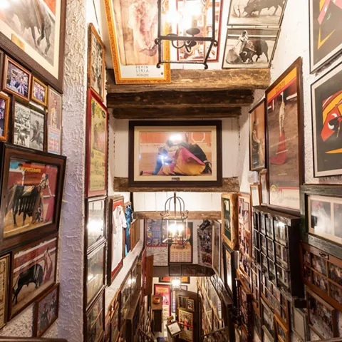 Escalera decorada con fotografías y carteles enmarcados