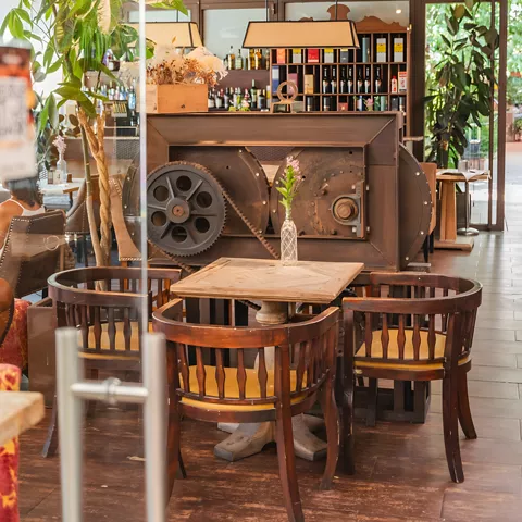 Comedor con barra central, mesas de madera y decoración industrial