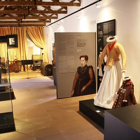 Galería expositiva con vestimenta histórica y paneles informativos
