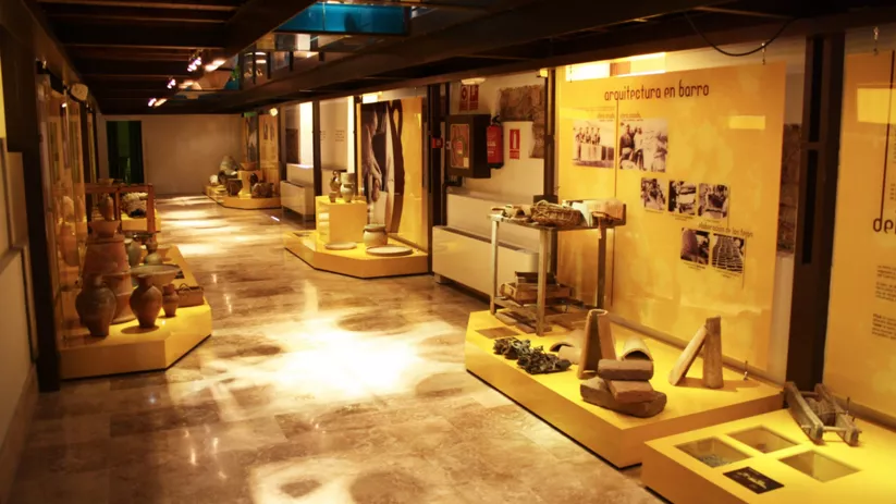 Sala museística con paneles informativos y objetos de barro