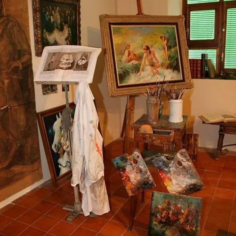 Espacio de taller artístico con caballete, lienzos y materiales de pintura