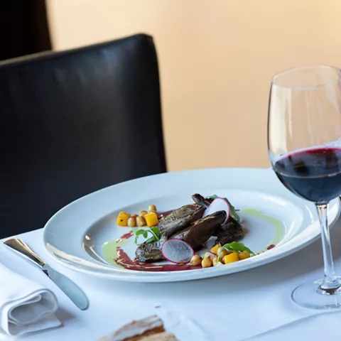 Plato gourmet con vino tinto