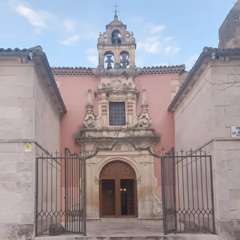 Entrada con espadaña y puertas de madera
