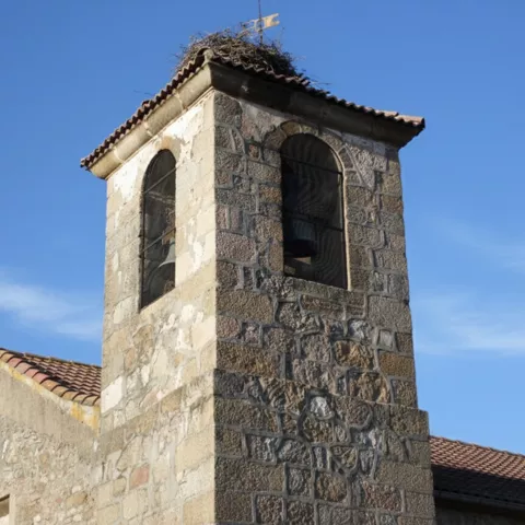 Campanario de piedra con campana y nido