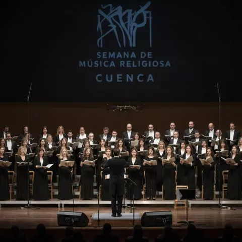 Coro interpretando música religiosa en sala de conciertos