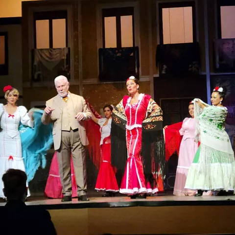 Reparto saludando al público con vestuario tradicional colorido