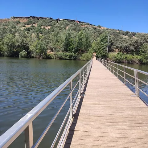 Pasarela peatonal sobre el río rodeado de vegetación