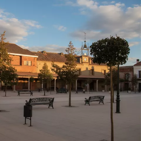 Plaza porticada con bancos y edificios tradicionales