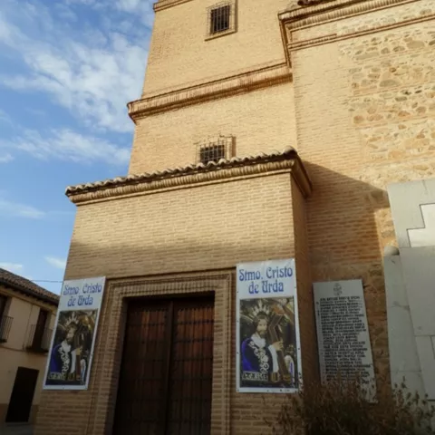 Torre de iglesia de ladrillo con carteles y portada principal