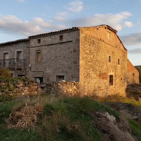 Casa de piedra en paisaje al atardecer