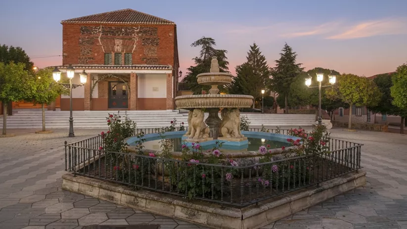 Plaza principal con fuente ornamental y edificio histórico al fondo