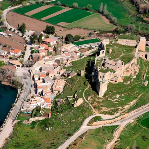 Vista aérea de pueblo con castillo en ruinas y río rodeando el casco urbano