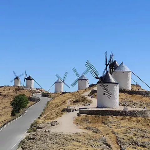 Vista amplia de molinos de viento en una colina bajo cielo despejado.
