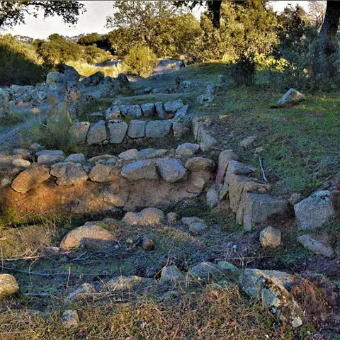 Restos arqueológicos de piedra en un claro del bosque