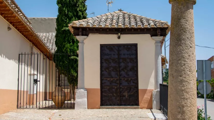Pequeña capilla junto a cruz de piedra
