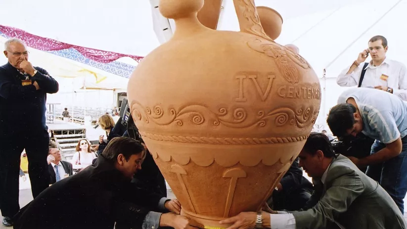 Gran vasija decorada rodeada de personas en una feria