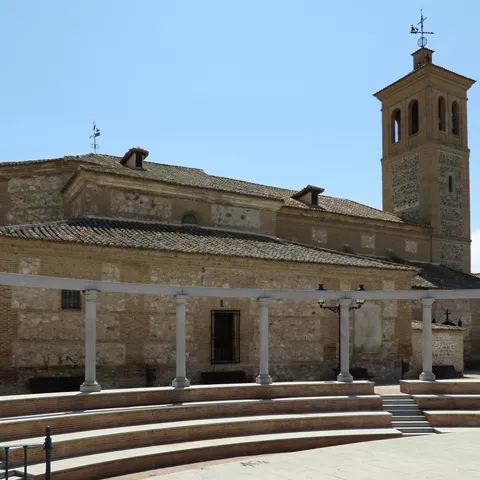 Iglesia de piedra y ladrillo con torre campanario