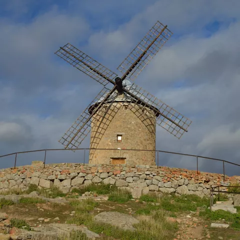 Molino de piedra restaurado sobre base circular de mampostería