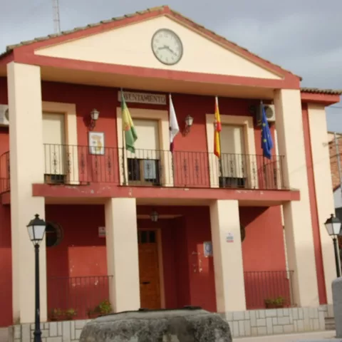 Fachada del ayuntamiento con soportales, reloj y banderas