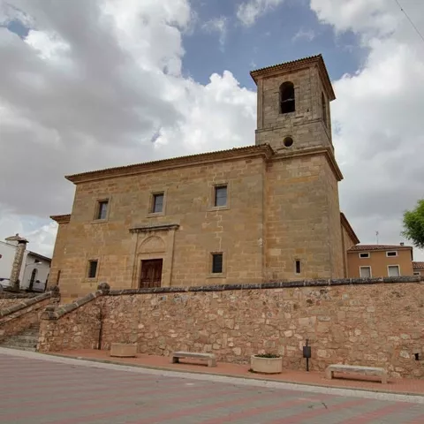 Iglesia de piedra sobre plaza con muro y escalinata