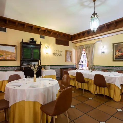 Comedor amplio con mesas redondas y decoración clásica