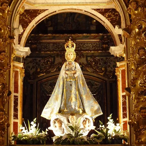Imagen religiosa en altar barroco con dorados y figuras ornamentales.