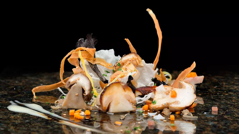 Composición de setas con láminas crujientes sobre fondo oscuro