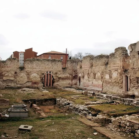 Patio interior en ruinas con muros de piedra.