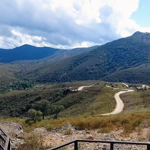 Mirador de montaña con carretera serpenteante entre colinas