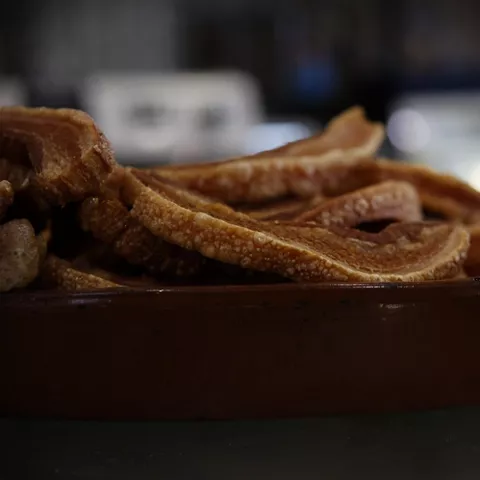 Primer plano de torreznos crujientes servidos en un plato.