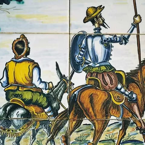 Escena de caballero y escudero a caballo frente a molinos de viento en azulejos tradicionales