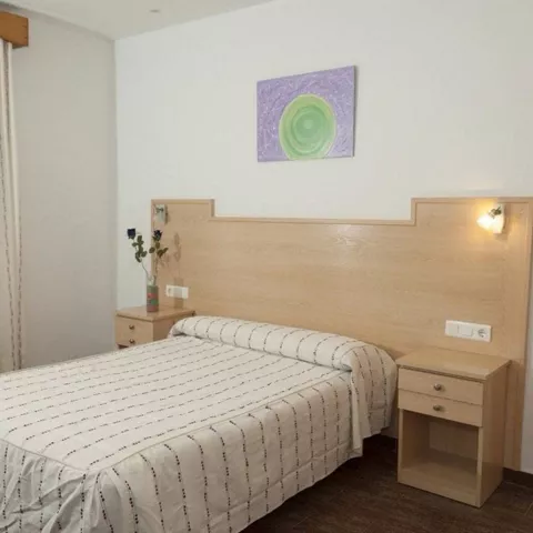 Habitación sencilla con cama doble y mesillas