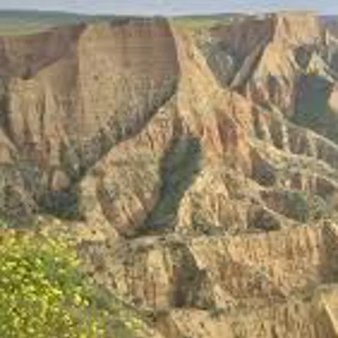 Barrancos y formaciones rocosas junto a un embalse rodeado de montes.