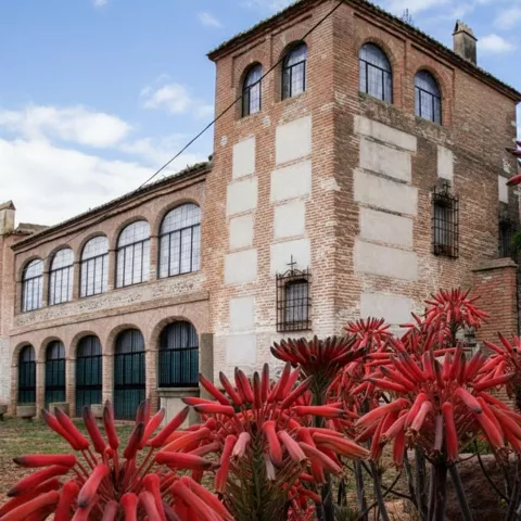 edificio histórico de ladrillo con ventanales arqueados