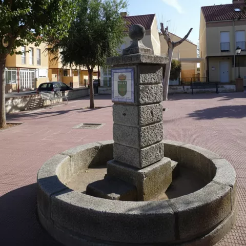 Plaza con pilón de piedra y viviendas alrededor