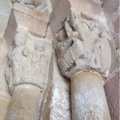 Capiteles esculpidos con figuras humanas y motivos narrativos.