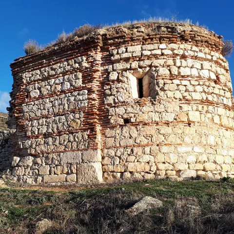 Pequeña construcción circular de piedra en el campo.