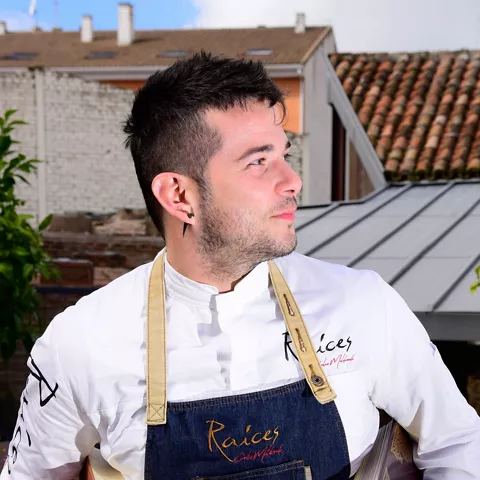 Cocinero con delantal mirando a un lado en una terraza