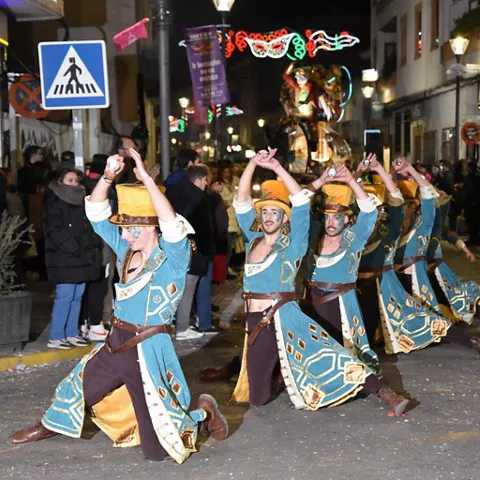 Bailarines con vestuario azul realizando una coreografía nocturna ante el público