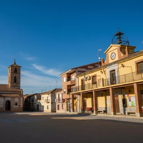 Plaza amplia con edificios históricos y campanario