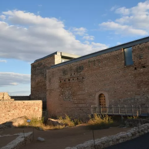 Zona restaurada del castillo de Calatrava la Vieja en Carrión de Calatrava con pasarela y puerta de acceso.