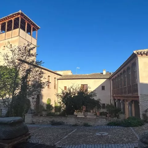 Patio interior con torre, árboles y galerías
