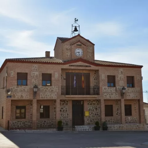 Edificio histórico de piedra con patio delantero ajardinado