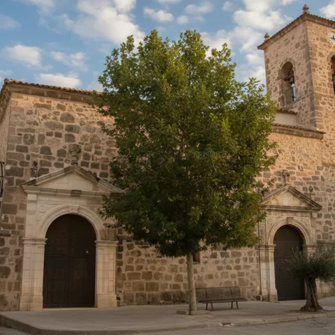 Iglesia de piedra con portada monumental y arbolado.