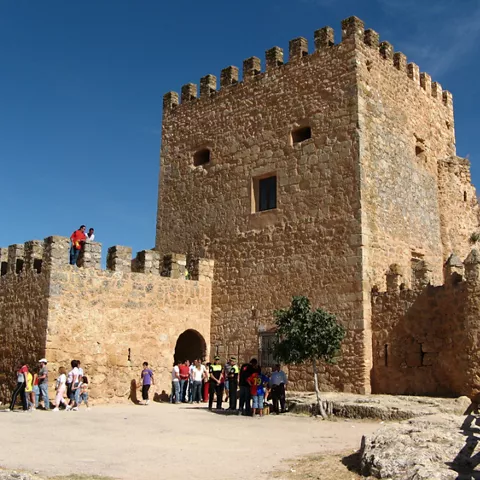 Patio interior de fortaleza con visitantes y torre principal