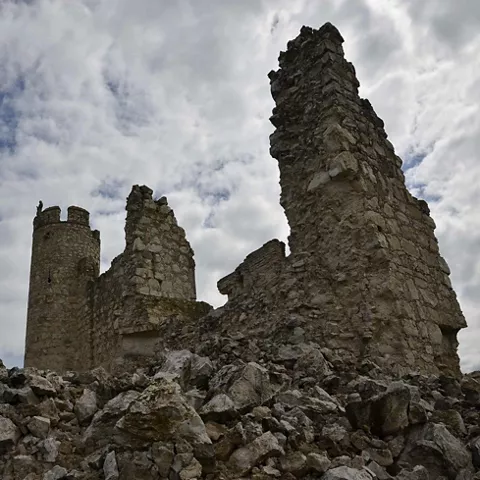 Ruinas de castillo de piedra entre escombros y nubes
