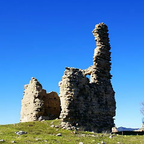 Restos de una construcción de piedra con abertura en un entorno natural.